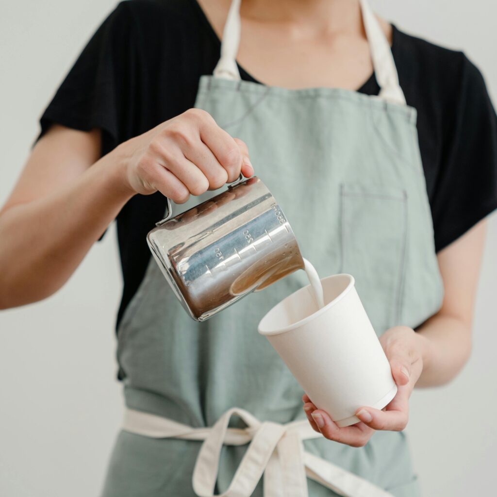 pexels-photo-4350055-4350055 Unrecognizable female worker pouring milk into coffee cup